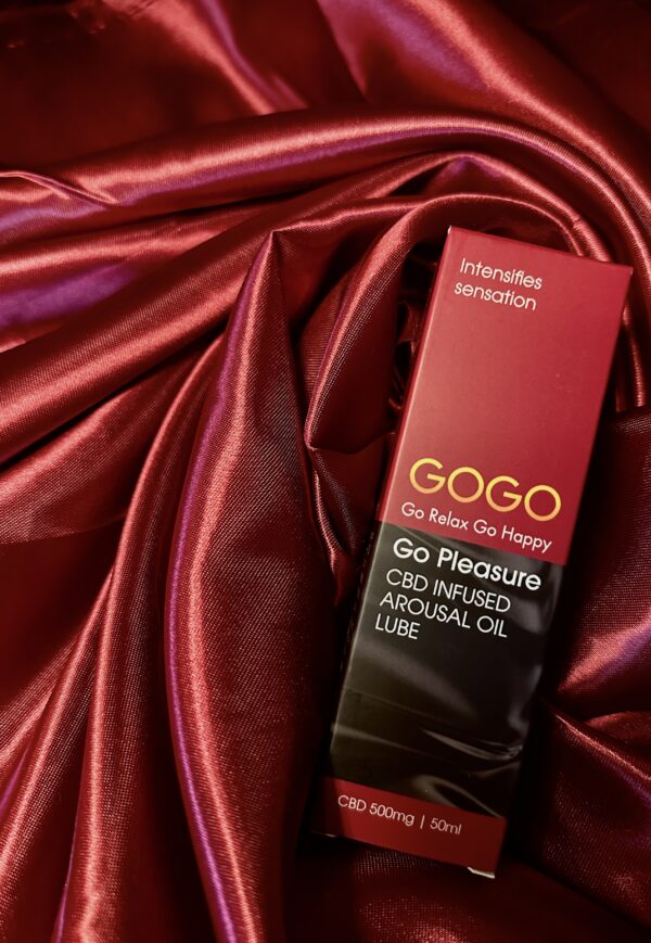 The gogo CBD oil arousal lube sat in a swirl of burgundy silk